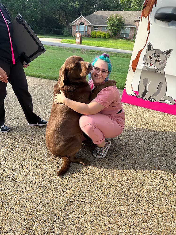 A veterinary technician hugging one of our dog patients
